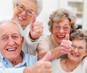 Happy senior adults showing thumbs up sign